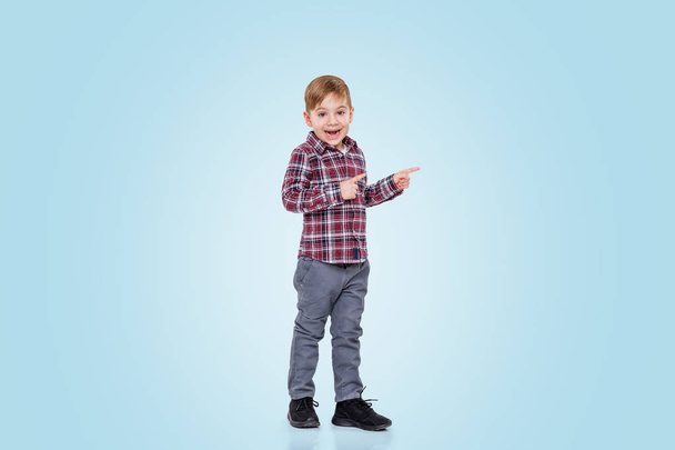 Full length of a little boy standing and pointing away - Fotoğraf, Görsel