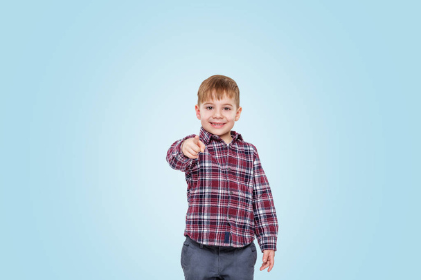 Portrait of a smiling little boy pointing finger at camera - Fotó, kép