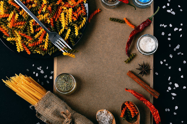 Bunch of spaghetti and colorful fusilli on corkboard - Foto, Imagem