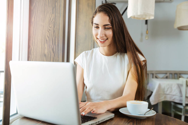 Pretty young business woman using laptop for work - Photo, Image