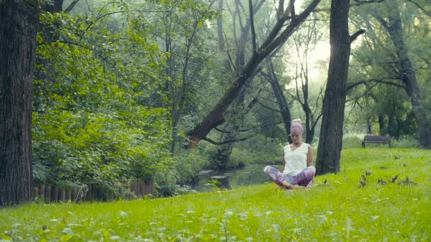 Žena, která dělá cvičení jógy u řeky - Záběry, video