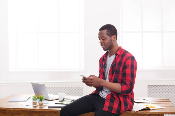Mladý černý podnikatel zahájit telefonní hovor na mobil v moderní bílé úřadu - Fotografie, Obrázek