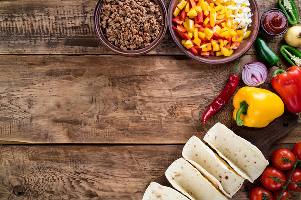 Mexicaanse taco's met groenten en vlees. Ingrediënt voor het koken van taco's al pastor op houten achtergrond. Bovenaanzicht - Foto, afbeelding