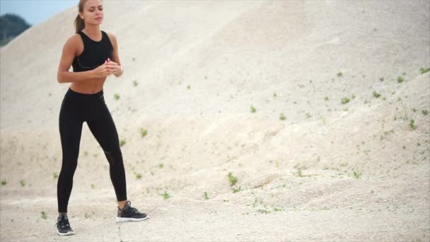 The athlete makes deep squats to strengthen the muscles, she is in nature - Footage, Video