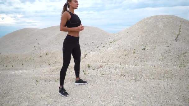 Girl doing squats exercise during workout outside the city - Footage, Video