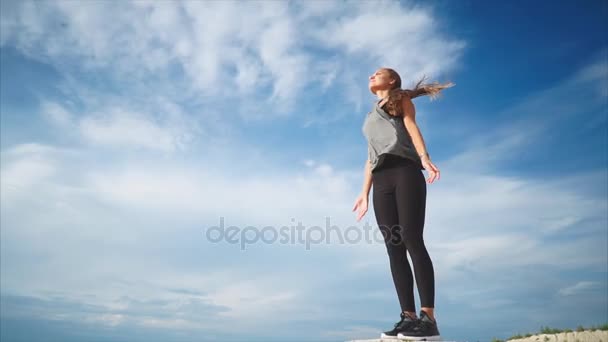 A young woman doing a solitary breathing exercise in nature fresh wind blows her - Footage, Video