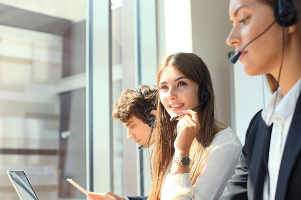 Attractive positive young businesspeople and colleagues in a call center office. - 写真・画像