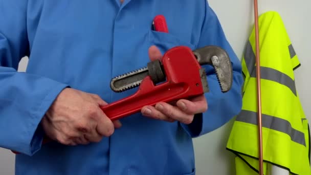 Klempner in blauen Overalls öffnet einen verstellbaren Schraubenschlüssel - Filmmaterial, Video