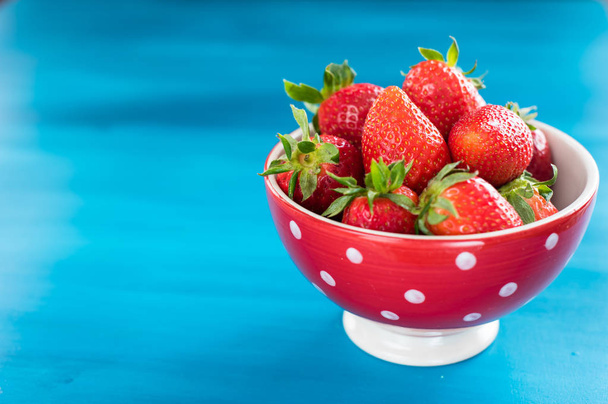 Ripe red strawberries on blue wooden table, Fresh strawberry, Strawberries in white bowl. - Zdjęcie, obraz