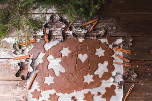 Випічка різдвяного печива. Розкачати тісто, щоб вирізати зірки та пряників на дерев'яному фоні
 - Фото, зображення