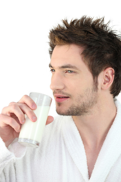 Man in bathrobe drinking milk - 写真・画像