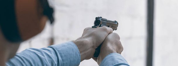 Shooting with a pistol. Man aiming pistol in shooting range. - Fotografie, Obrázek