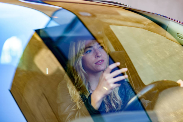 Jovem mulher mensagens de texto durante a condução do carro
 - Foto, Imagem