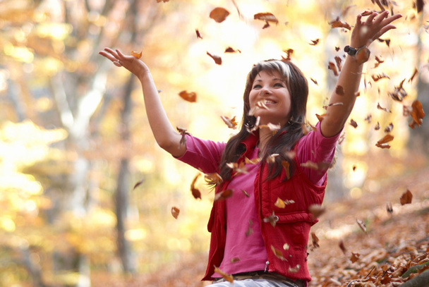 mooi meisje met vallende bladeren - Foto, afbeelding