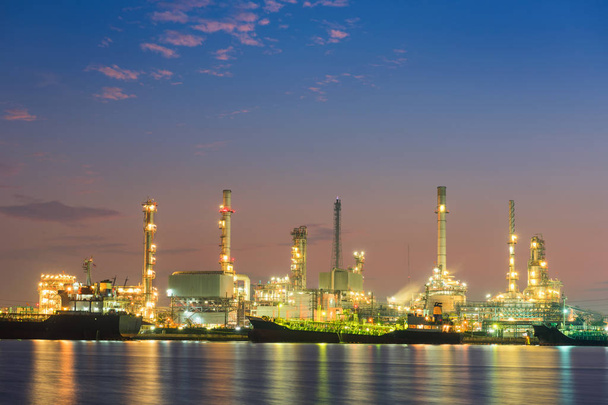 Transport logistiek en olie raffinaderij plant bij blauwe uur zon - Foto, afbeelding