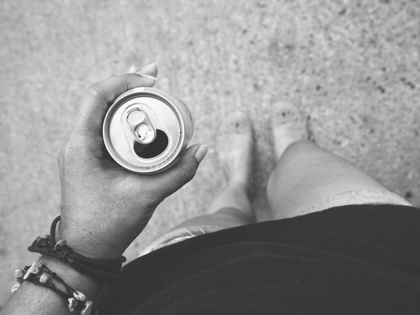 black and white photo of woman holding can with soda drink in hand - Photo, Image
