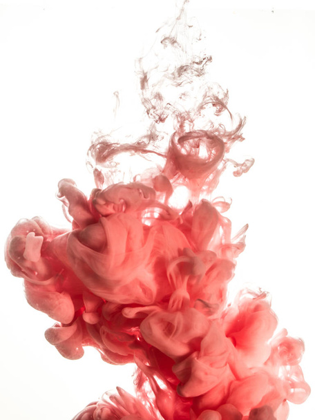 Ink swirl in water isolated on white background. The paint in the water. Soft dissemination a droplets of pink ink in water close-up. Abstract background. Explosion of splashes yellow acrylic ink - Fotografie, Obrázek