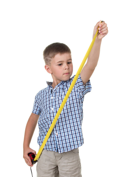 Adolescent mignon garçon en chemise à carreaux bleu, avec un ruban à mesurer sur fond blanc isolé, concept de construction
 - Photo, image
