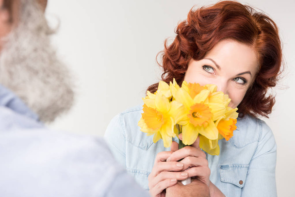mature woman with daffodils - Φωτογραφία, εικόνα