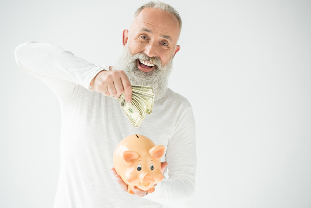 homem com dólares e mealheiro
 - Foto, Imagem