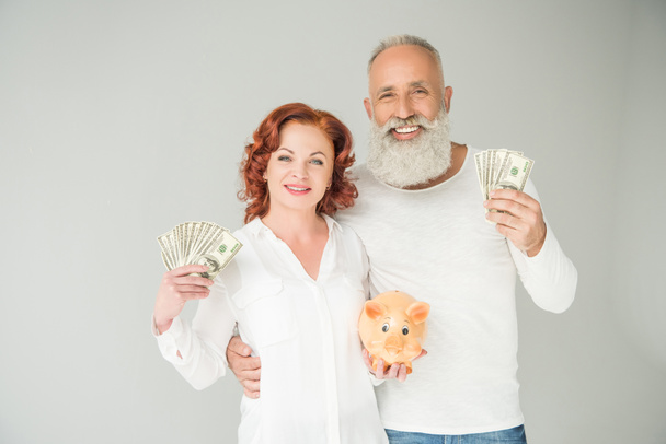 couple with dollars and piggy bank - Φωτογραφία, εικόνα