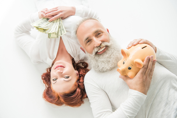 echtpaar met dollars en piggy bank - Foto, afbeelding