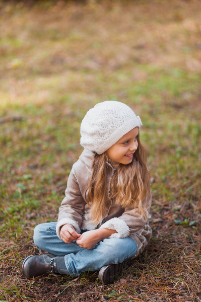Portrait of a beautiful little girl in an autumn park - Фото, зображення