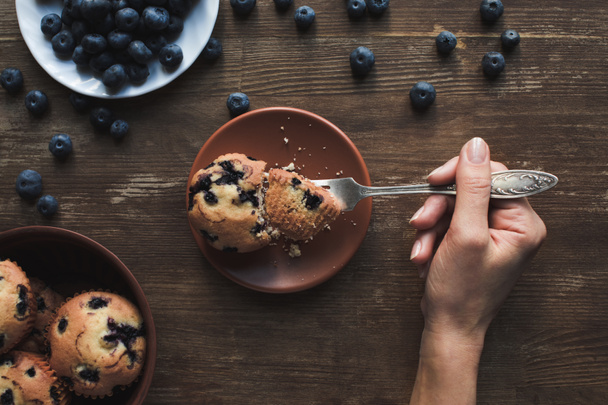 person eating muffin with blueberries - Fotó, kép