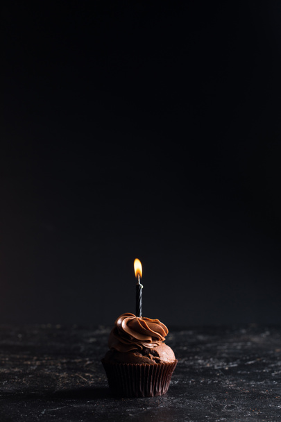 チョコレートのカップケーキとキャンドル - 写真・画像