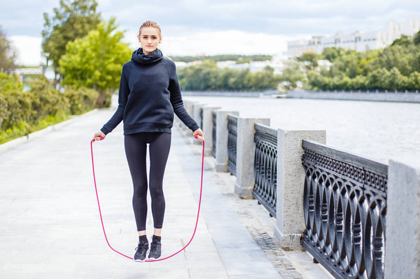 Sporty woman warming up with jump rope outdoors - Φωτογραφία, εικόνα