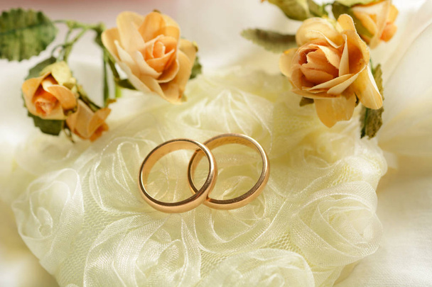 Χρυσά δαχτυλίδια γάμου με λουλούδια γύρω από - Φωτογραφία, εικόνα