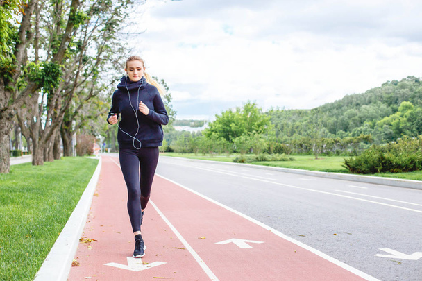 Athletic woman running outdoors. Action and healthy lifestyle concept. - Φωτογραφία, εικόνα