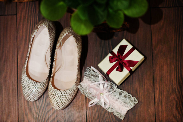 Close-up photo of wedding shoes, garter and tiny box with red ri - Photo, Image