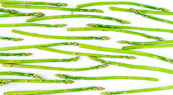 Fresh green asparagus shoots pattern, top view. Isolated over white. Food background asparagus flat lay pattern - Foto, Imagem