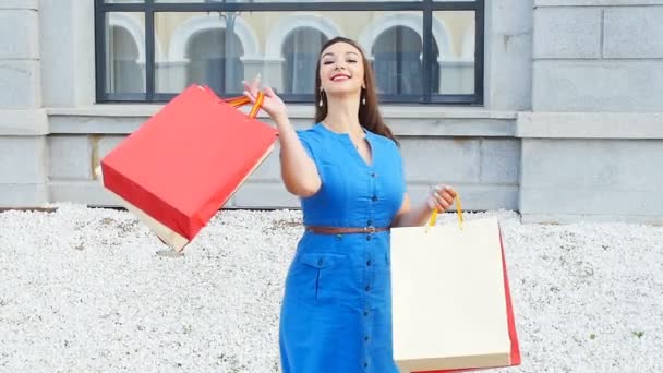 lachende jonge vrouw met shopping tassen - Video