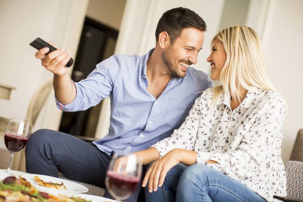 Young couple enjoying eating pizza and watching tv - Zdjęcie, obraz