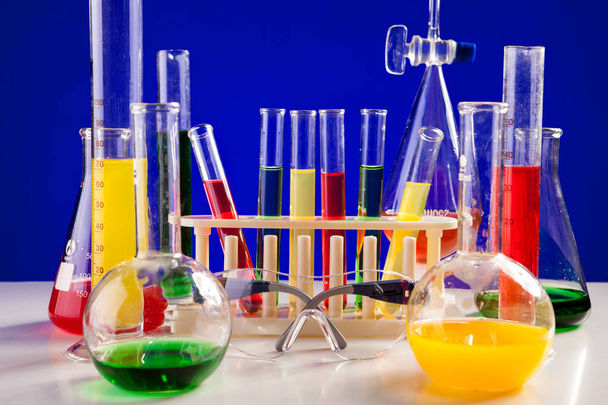 anderes Chemielabor auf einem Tisch vor blauem Hintergrund - Foto, Bild