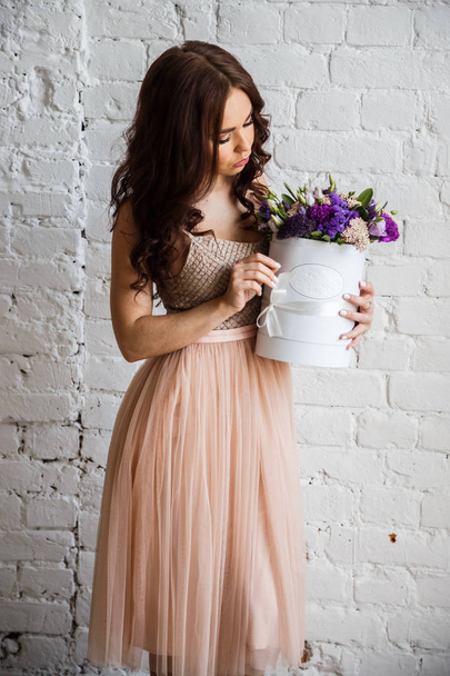 Young brunette in beautiful dress with flowers - Zdjęcie, obraz