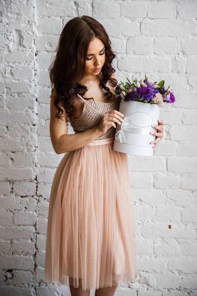 Young brunette in beautiful dress with flowers - Foto, afbeelding