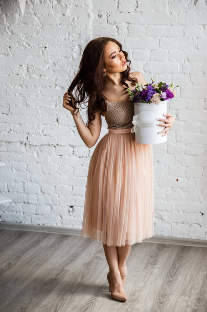 Young brunette in beautiful dress with flowers - Zdjęcie, obraz