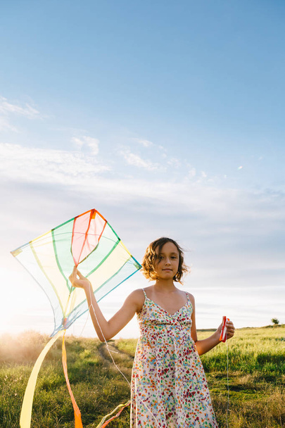 Girl holding kite and running in field - Фото, зображення