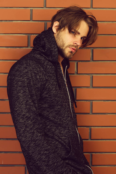 Bearded young man with messy hair and grey hoodie - Foto, afbeelding