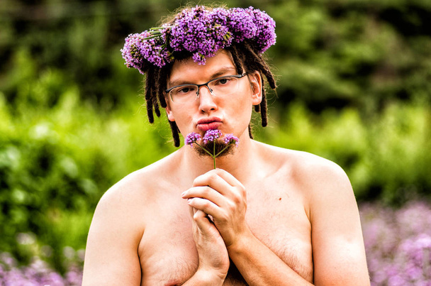 homem engraçado com dreadlocks detém uma flor
 - Foto, Imagem