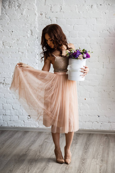 Young brunette in beautiful dress with flowers - Foto, Imagen