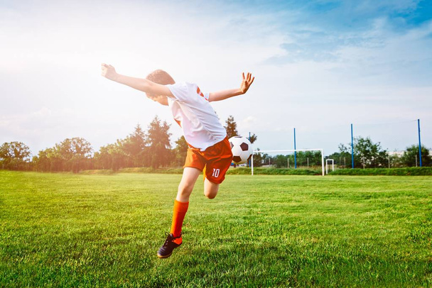 Boy playing with football ball on playing field. - Foto, Bild