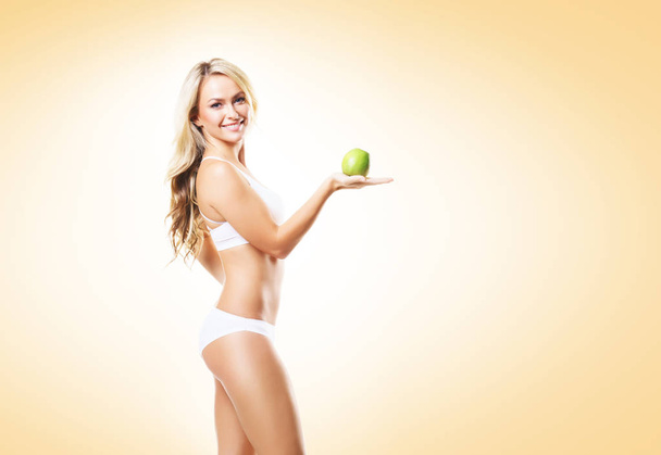 woman in white lingerie with green apple - Foto, imagen