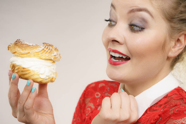 Funny woman holds cream puff cake - Photo, Image