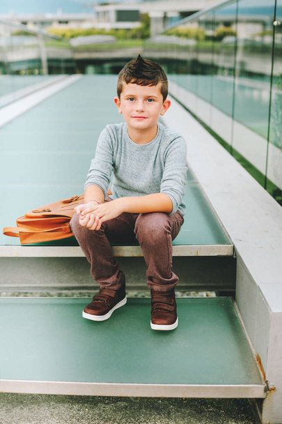 Outdoor portrait of happy young kid boy. Fashion schoolboy resting outside. Back to school concept - Foto, Imagen