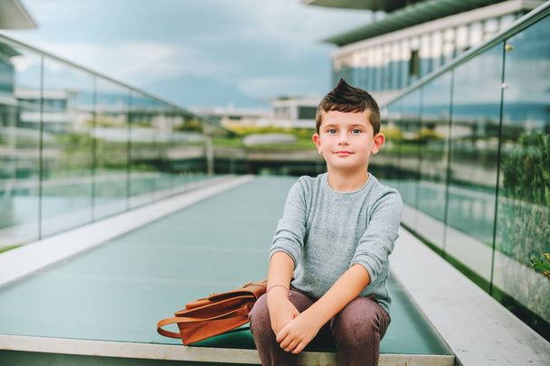 Outdoor portrait of happy young kid boy. Fashion schoolboy resting outside. Back to school concept - Photo, image