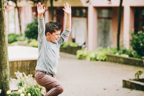 Смешной маленький мальчик танцует под дождем
 - Фото, изображение